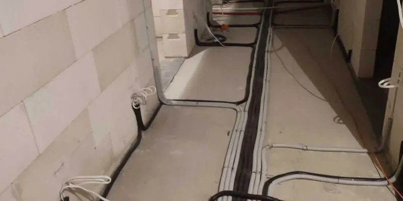 Trasy kablowe instalacji elektrycznej prowadzone po ścianach domu w stanie surowym